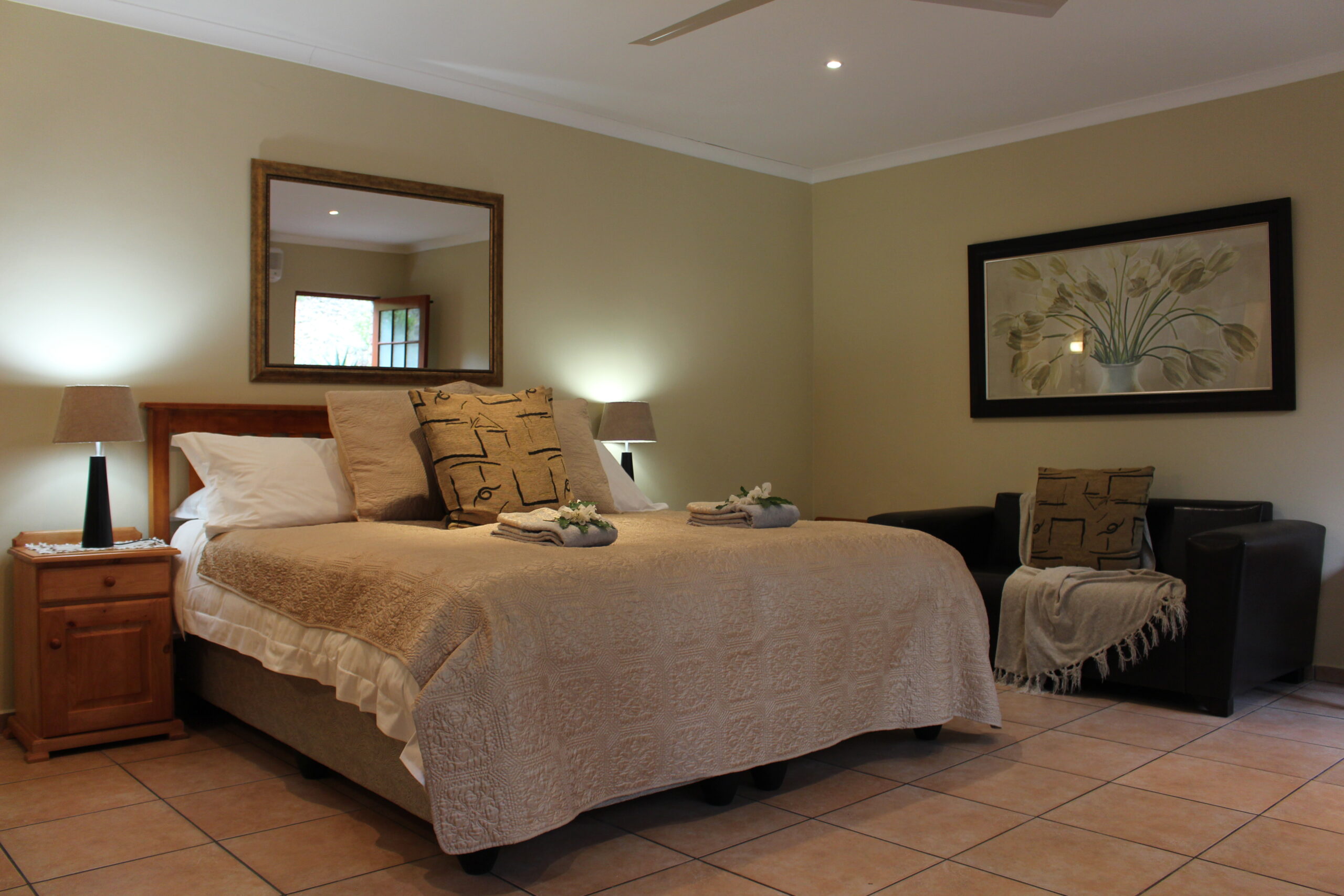 Cozy bedroom with a large bed, two nightstands, and a single chair.