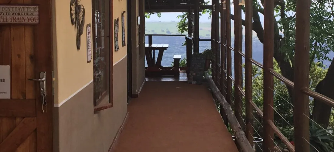 Wooden walkway with lake view surrounded by trees leading to a picnic table