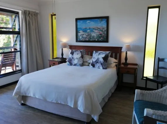Bedroom with a neatly made bed bedside tables and a window view