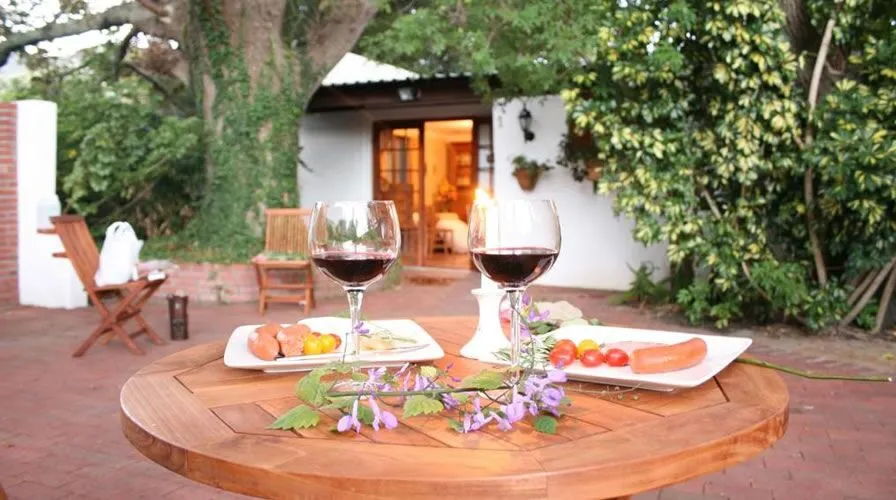 Wooden table with wine glasses food and flowers in a garden setting