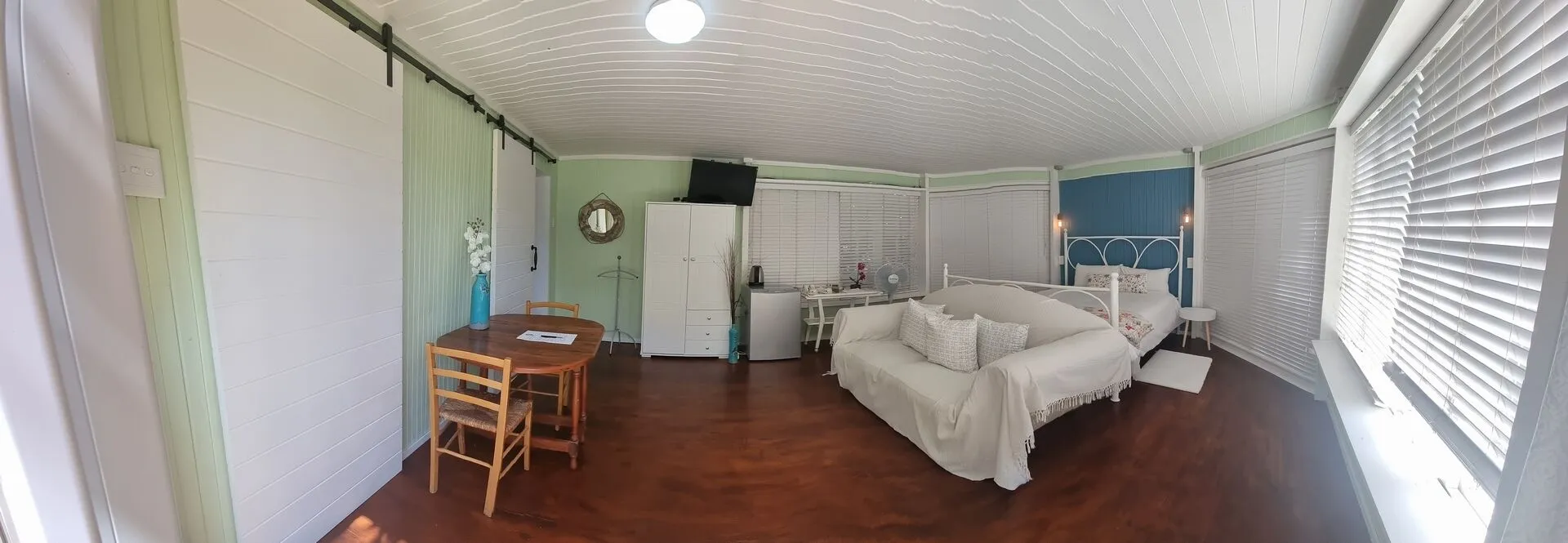 Cozy room with white furniture wooden table and large windows with blinds