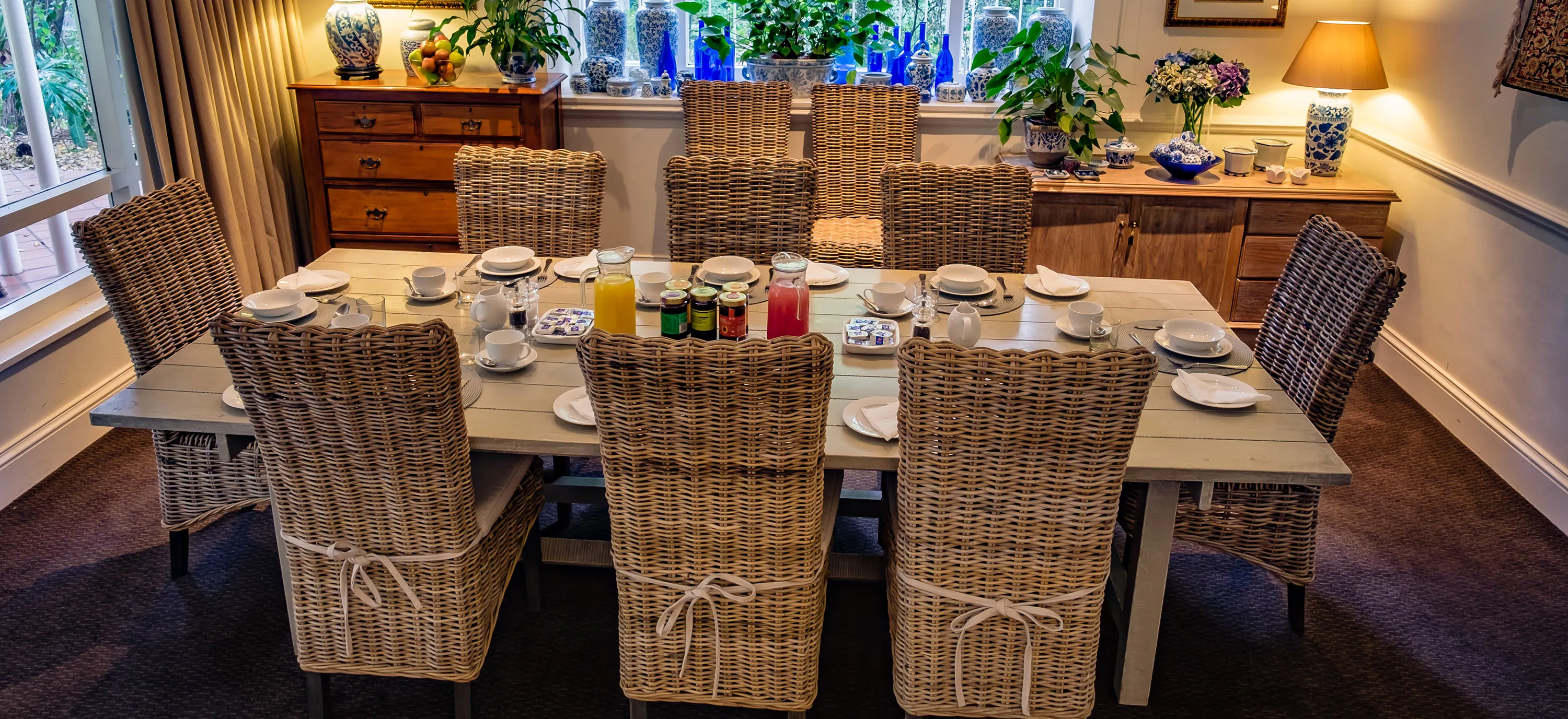 Dining table set with chairs in a cozy decorated room with large windows