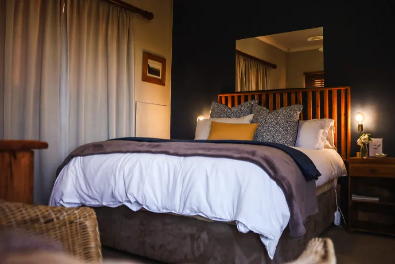 Cozy bedroom with a large bed wooden headboard and warm lighting