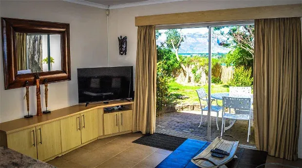 Living room with TV mirror and view of garden through sliding glass doors