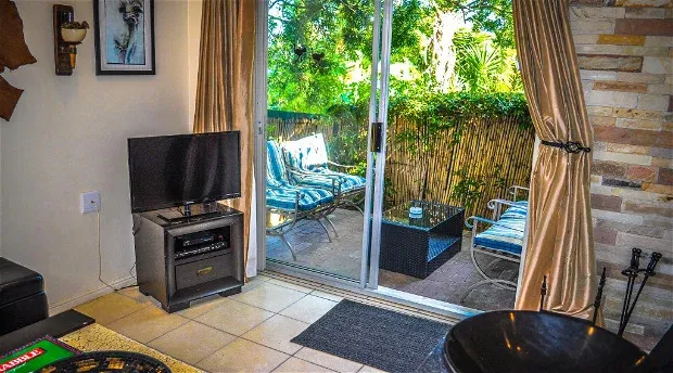 Living room with TV sliding glass door to patio and stone wall