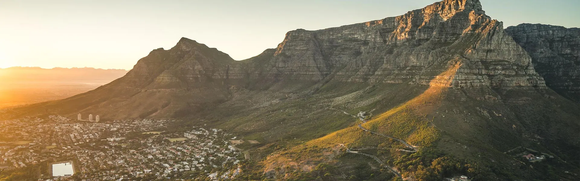 Mountain range with city at its base during sunset