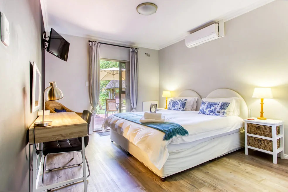 Modern bedroom with a large bed desk and patio access