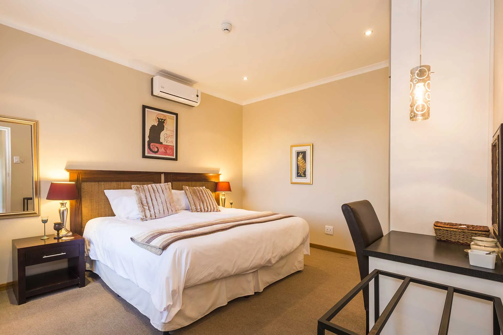 Cozy bedroom with double bed nightstand lamp desk and wall art