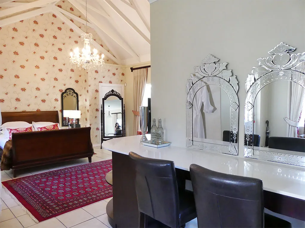 Bedroom with a bed vanity area and floral wallpaper