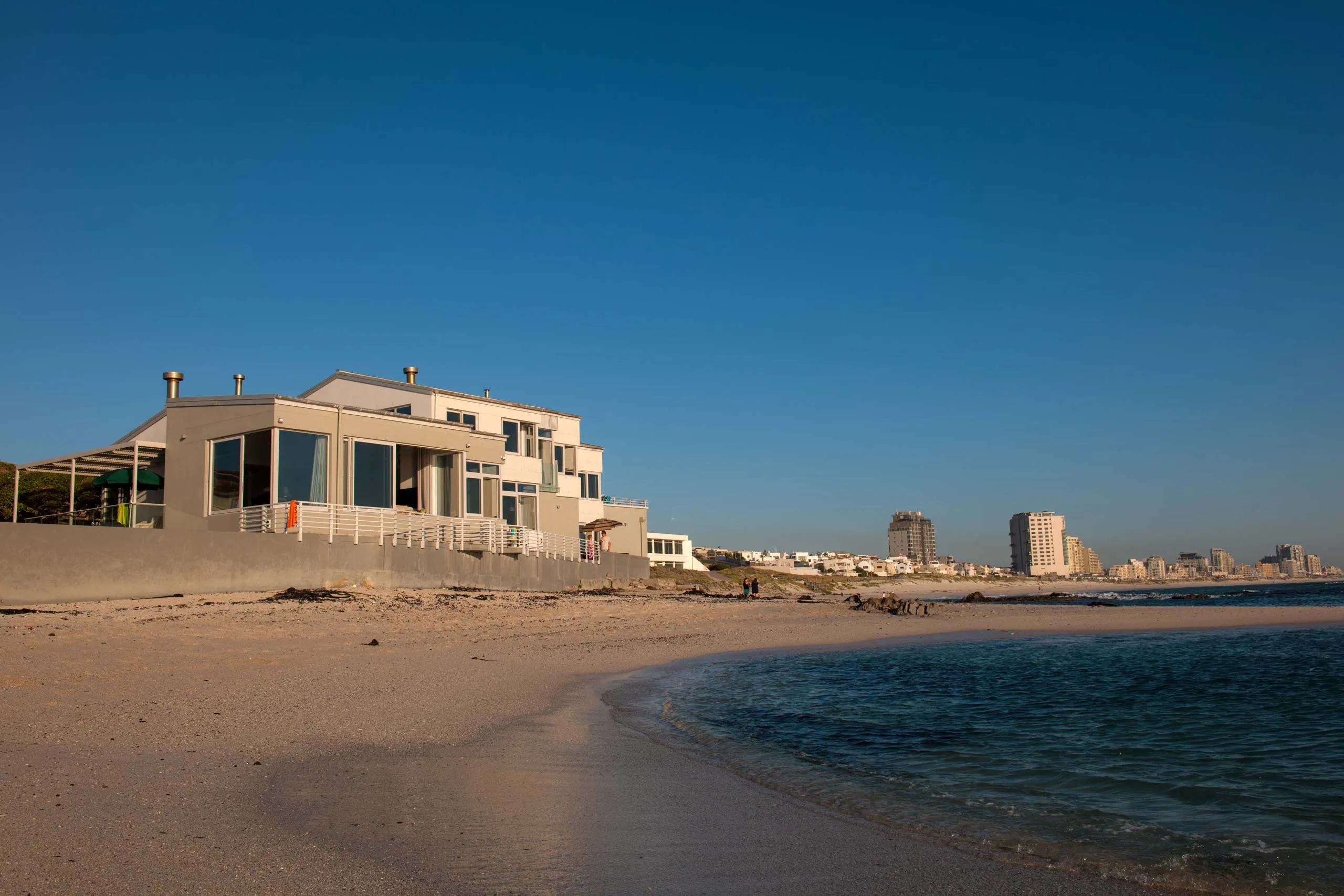 Modern beachfront house with large windows and calm ocean view