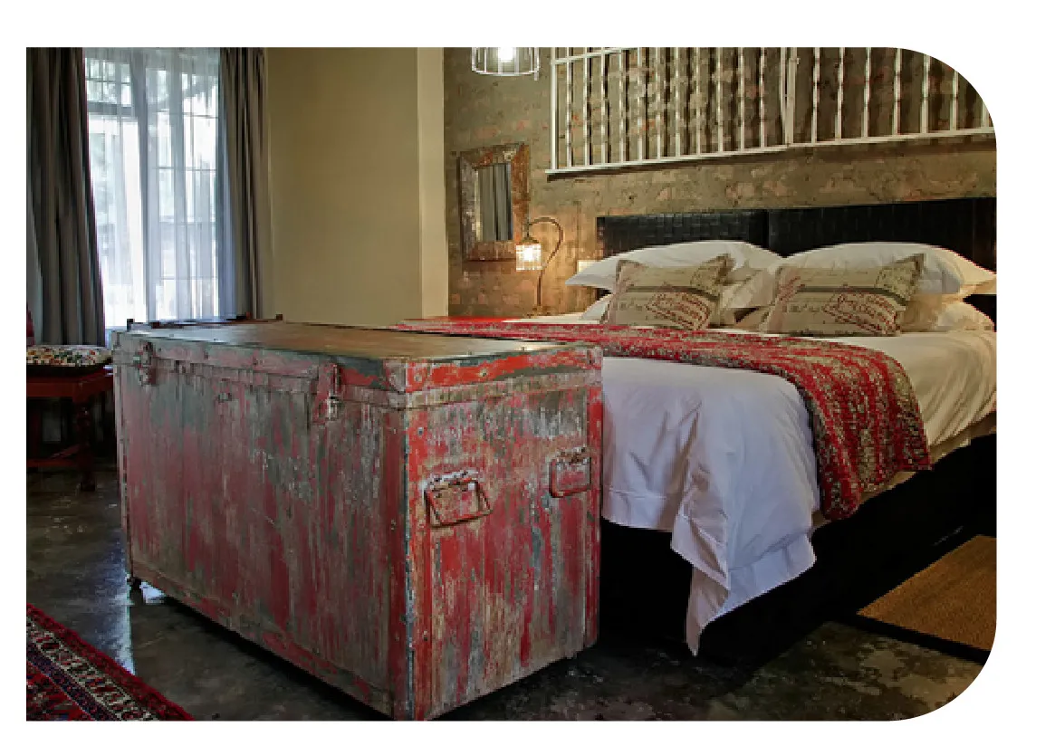 Vintage trunk at the foot of a bed in a cozy bedroom
