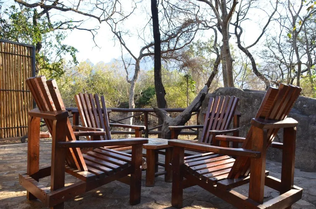 Four wooden chairs around a small table in a natural outdoor setting