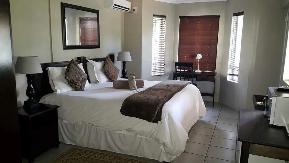 Bedroom with a large bed desk and window blinds