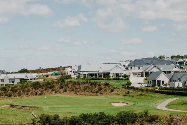Golf course with green fairway and houses in the background