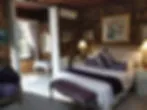 Blurry image of a bedroom with a bed pillows and bedside lamps