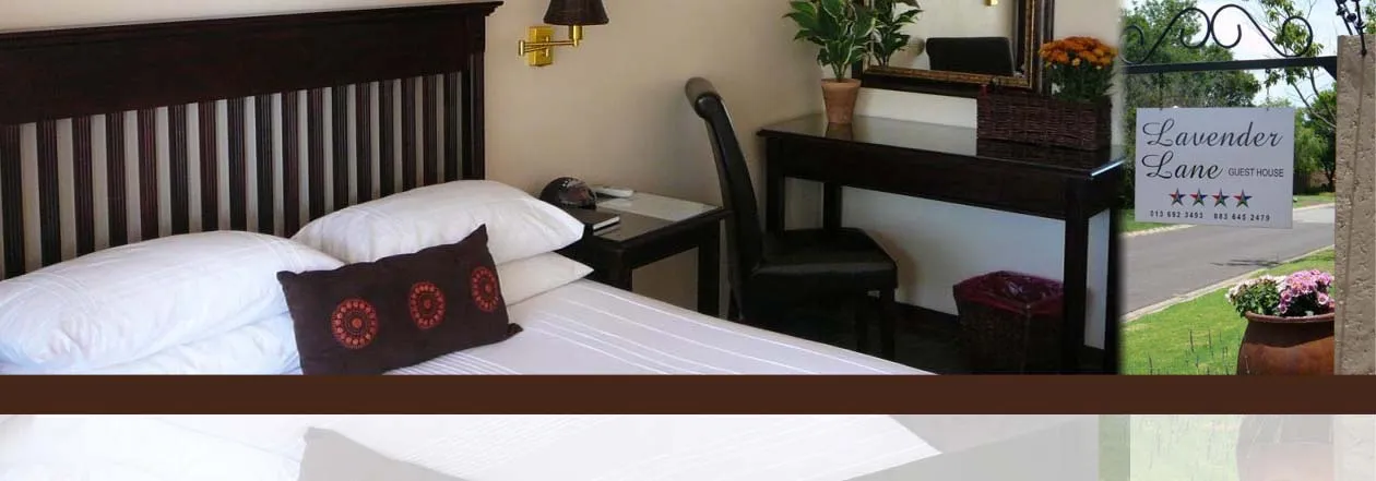 Bedroom with a bed desk and sign for Lavender Lane Guest House