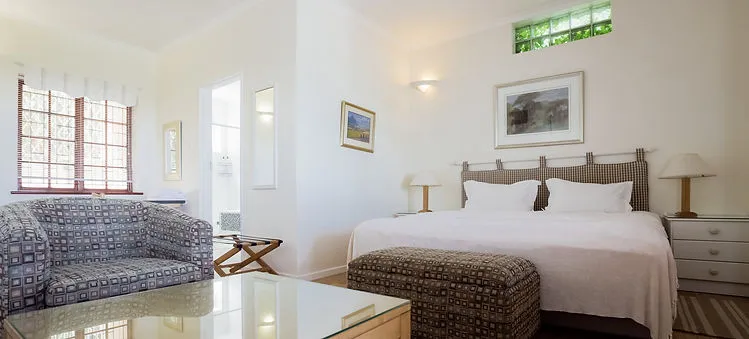 Bright bedroom with a bed armchair and large windows