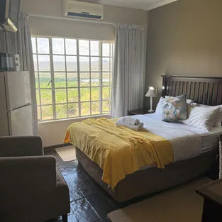 Cozy bedroom with large window yellow blanket and countryside view