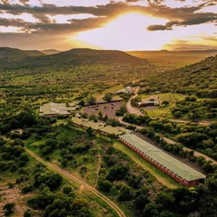 Aerial view of buildings in a lush valley at sunset