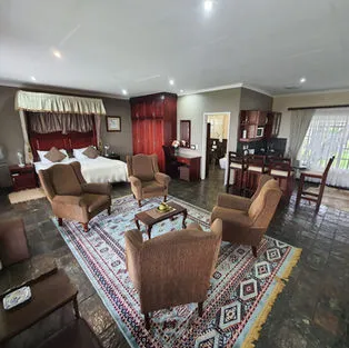 Bedroom with seating area desk and large windows in a spacious room