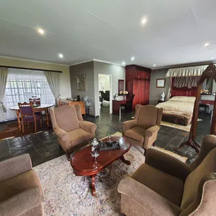 Cozy living room with armchairs coffee table and view of bedroom and dining area