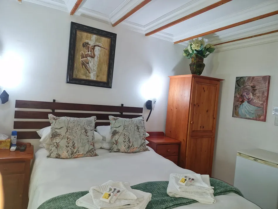 Cozy bedroom with neatly made bed wooden furniture and wall art