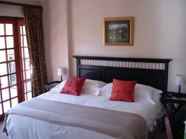 A neatly made bed in a bedroom with a framed picture on the wall
