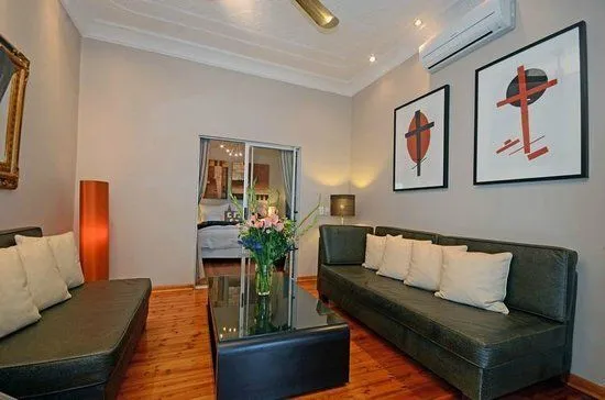 Modern living room with two black sofas wooden floor and abstract wall art