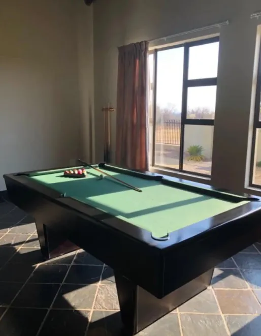 Pool table in a room with large windows and curtains