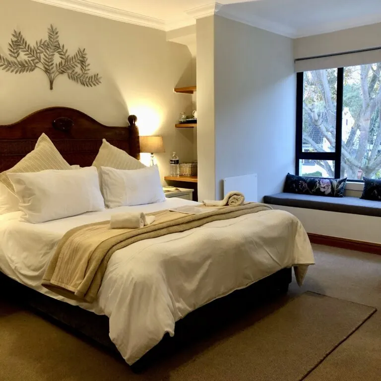 Cozy bedroom with large bed side table and window seat