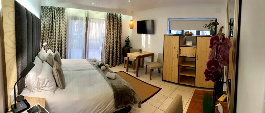 Modern bedroom with two beds wooden cabinet and large windows with curtains