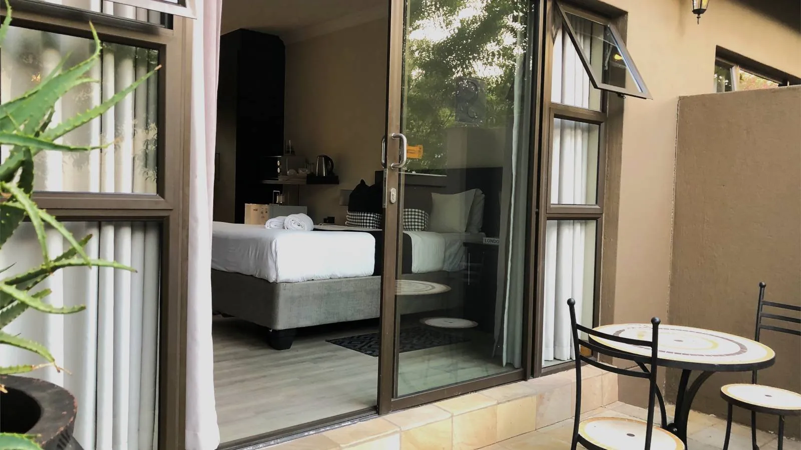 Patio with table and chairs outside a bedroom with sliding glass doors