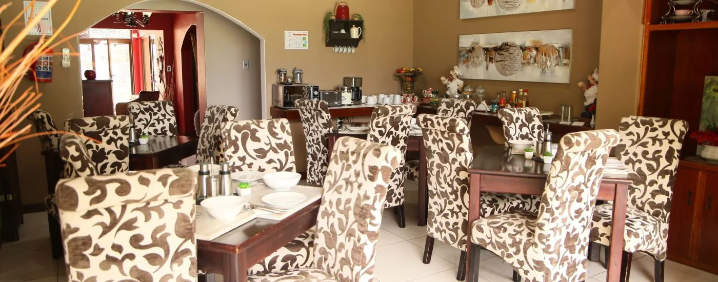Dining area with patterned chairs wooden tables and wall art in a restaurant