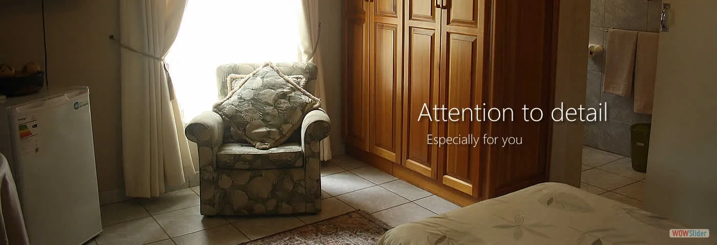 Bedroom with armchair wooden wardrobe and sunlight through curtains Text Attention to detail