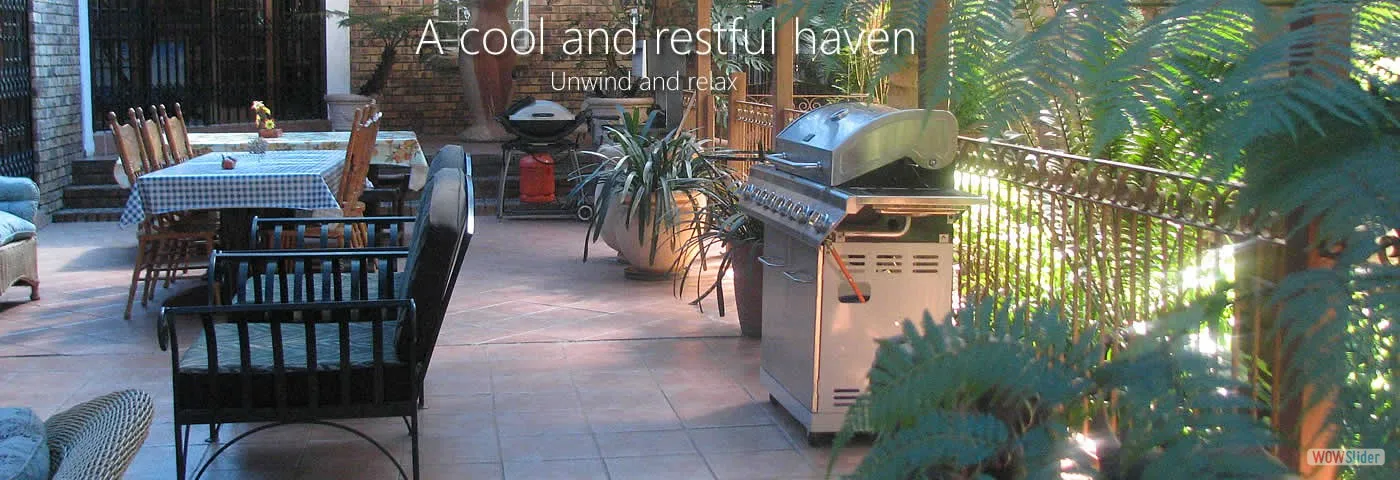 Patio with table chairs grill and plants text reads A cool and restful haven