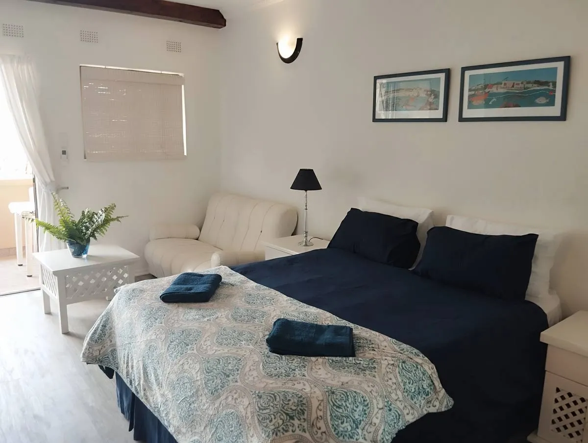 Cozy bedroom with a large bed sofa and two framed pictures on the wall