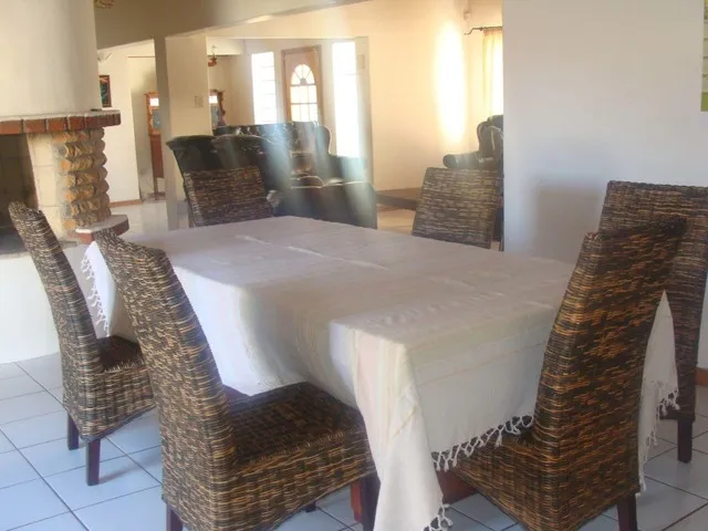 Dining area with table chairs and fireplace in a bright room