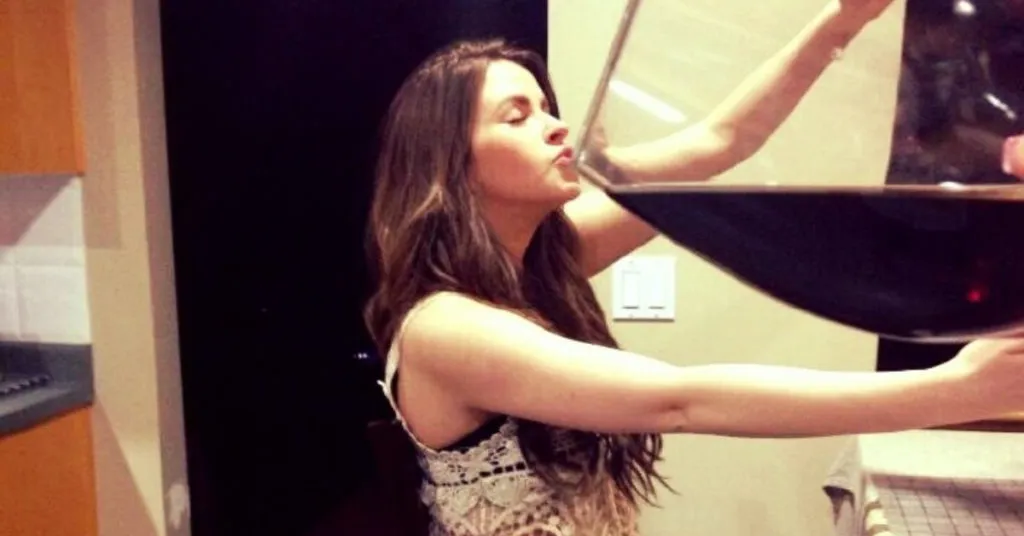 Woman blowing on a large bowl of soup in a kitchen