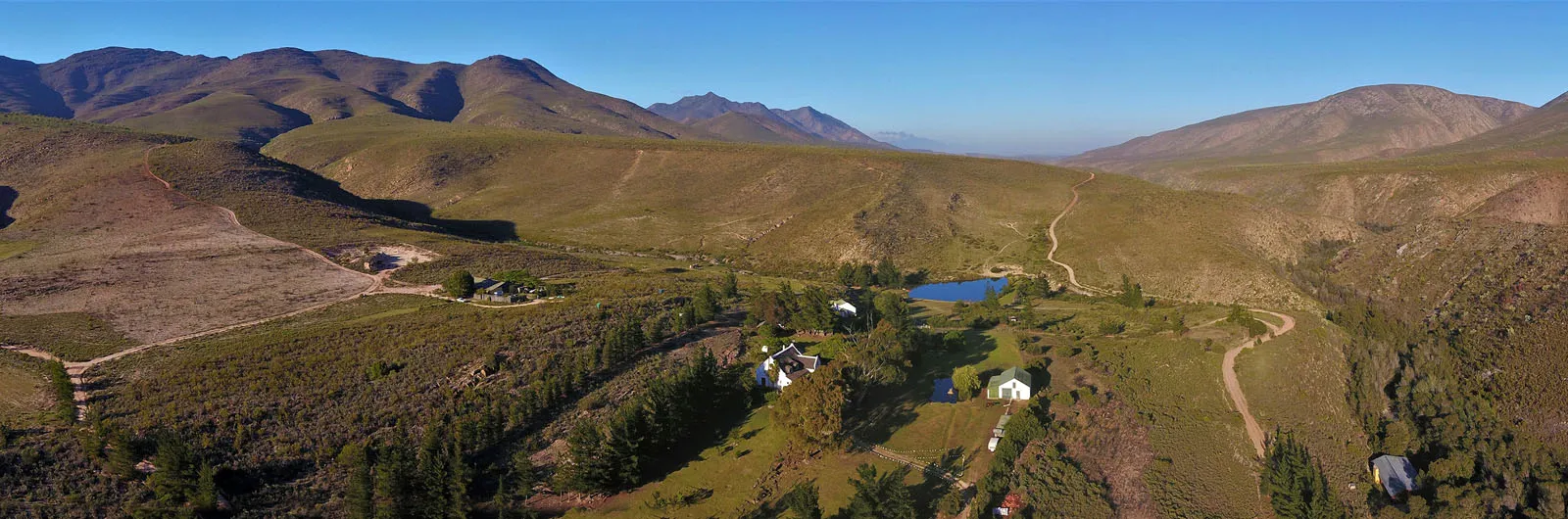 Aerial view of a rural landscape with scattered houses and rolling hills