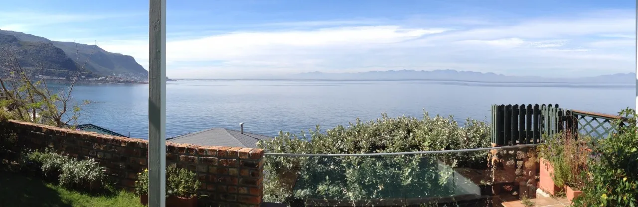 Scenic view of a bay with mountains greenery and a brick wall