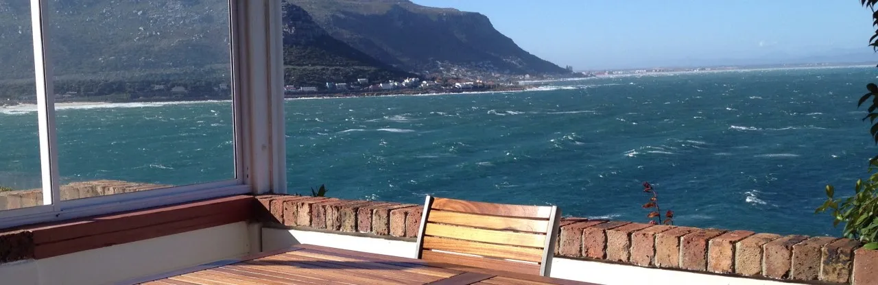 Wooden chair at a table with ocean view from a seaside balcony