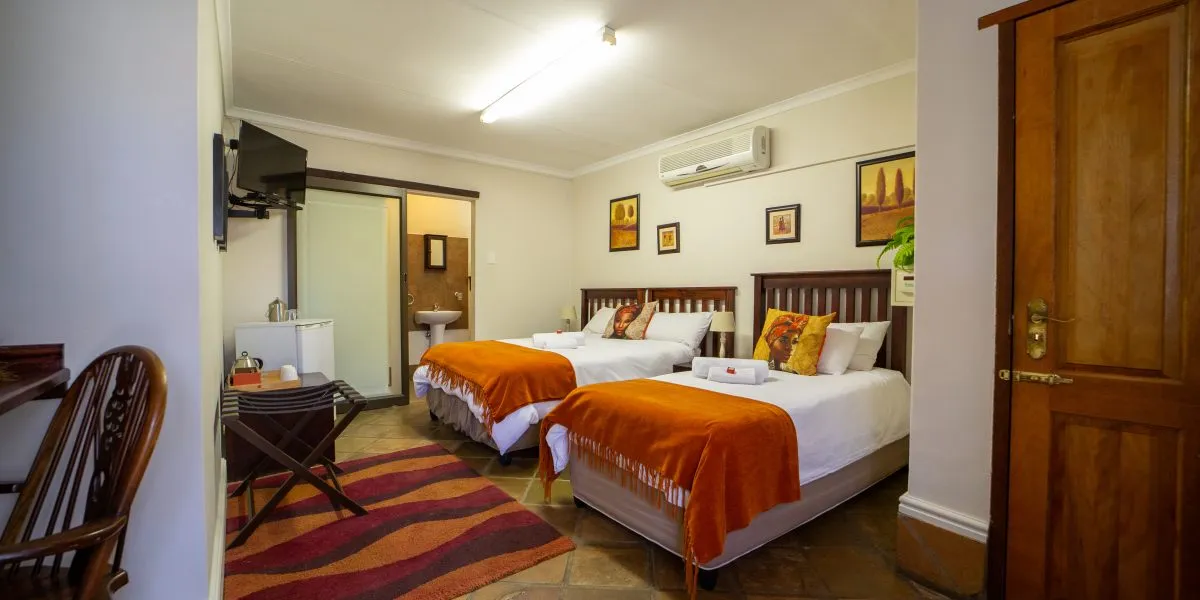 Twin bedroom with wooden furniture colorful decor and a TV