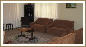 Living room with two brown sofas a coffee table and a cabinet