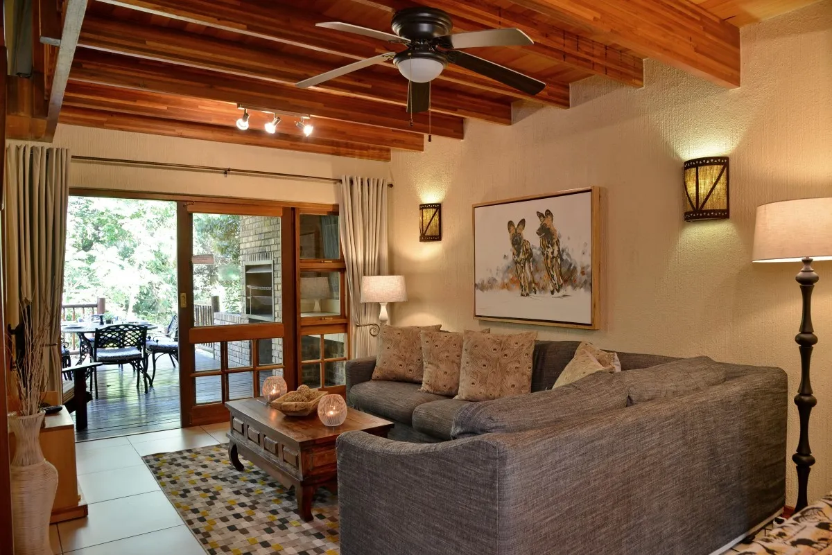 Cozy living room with sectional sofa wooden ceiling and large windows to patio