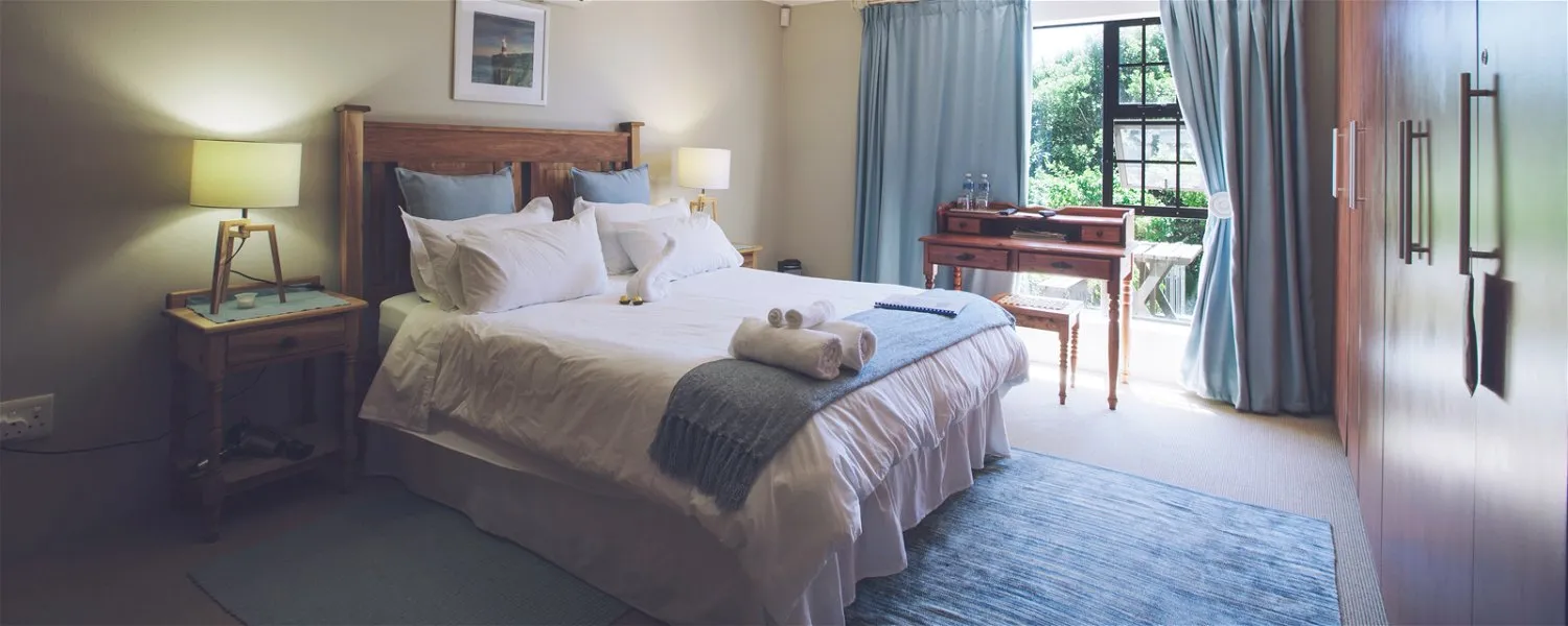 Cozy bedroom with a large bed blue accents and a window view