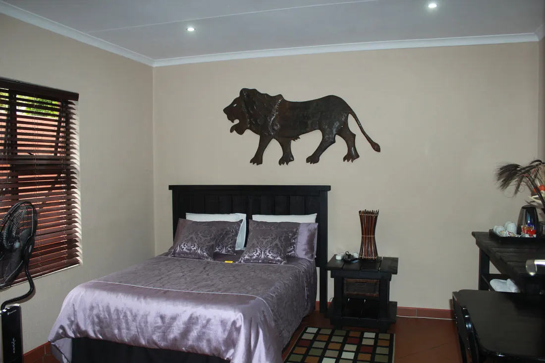 Bedroom with a large bed animal wall art and wooden furniture