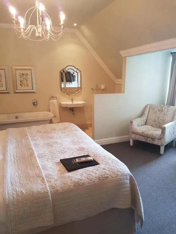 Bedroom with a bed armchair sink and chandelier in a cozy setting