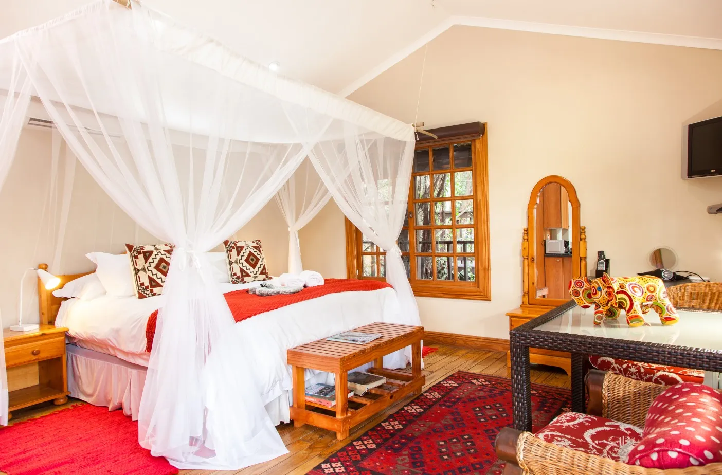 Fourposter bed with canopy in a cozy decorated bedroom with wooden furniture