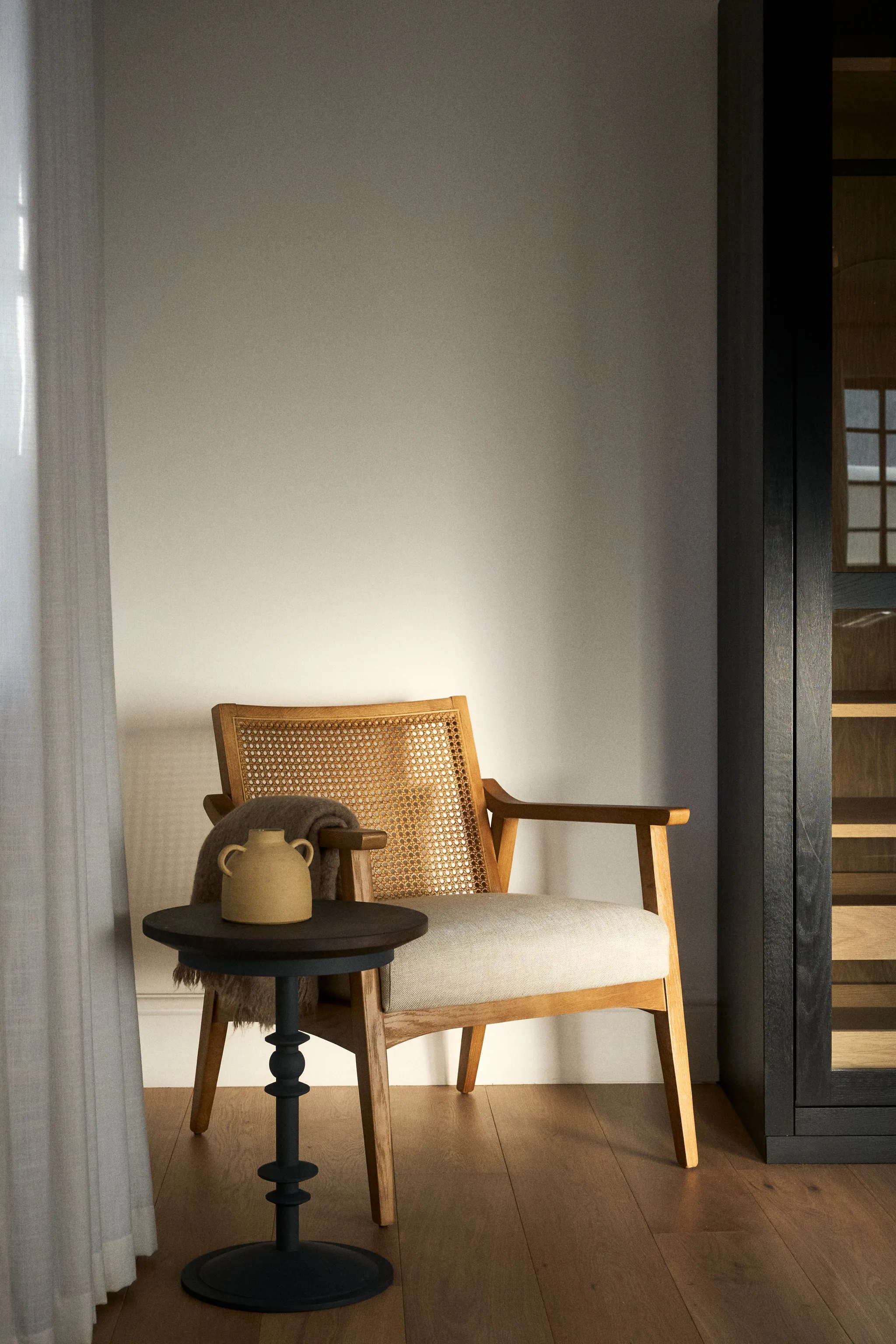 Wooden chair with side table and lamp in a modern room with wooden floor