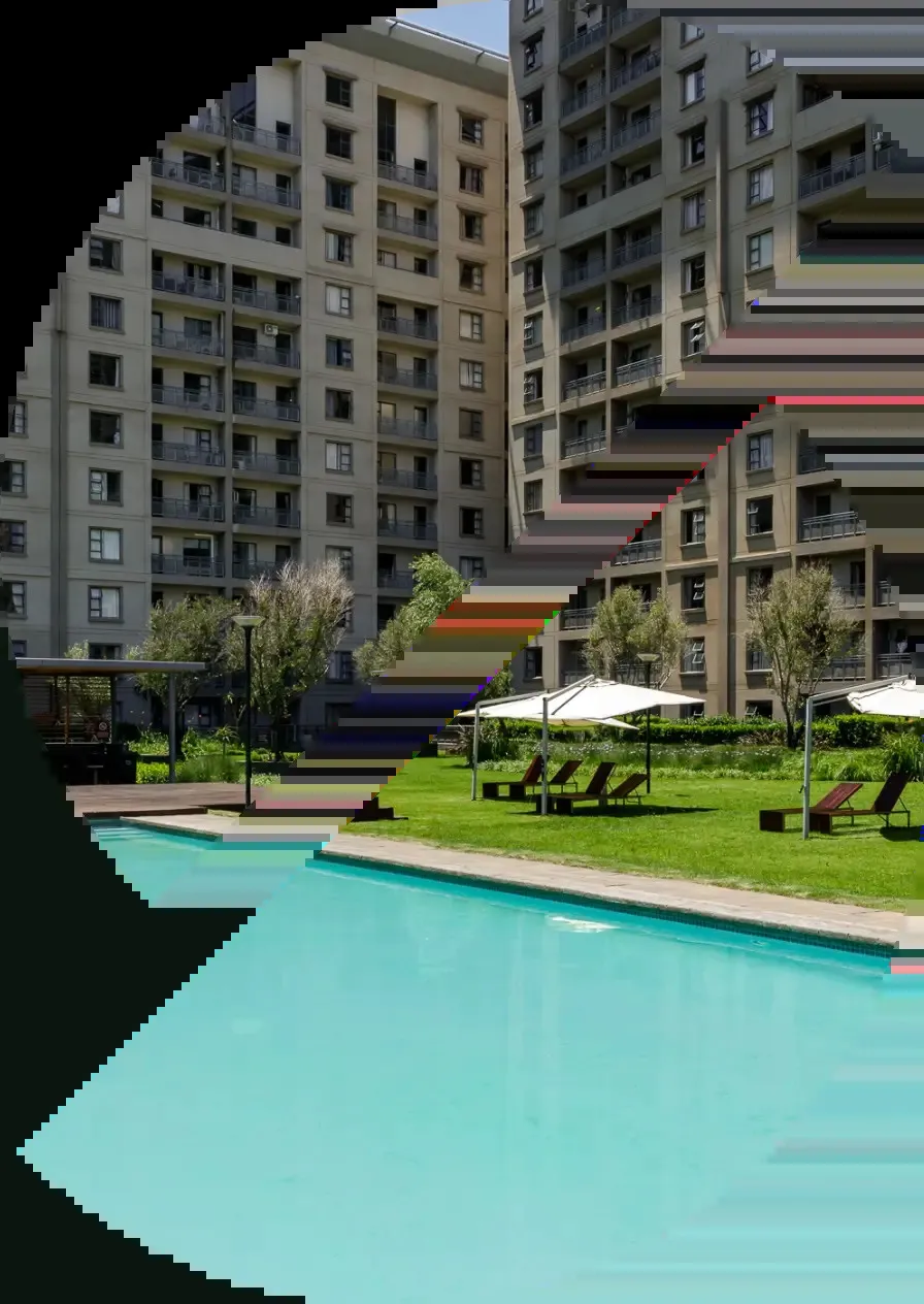 Swimming pool with lounge chairs and multistory buildings in the background